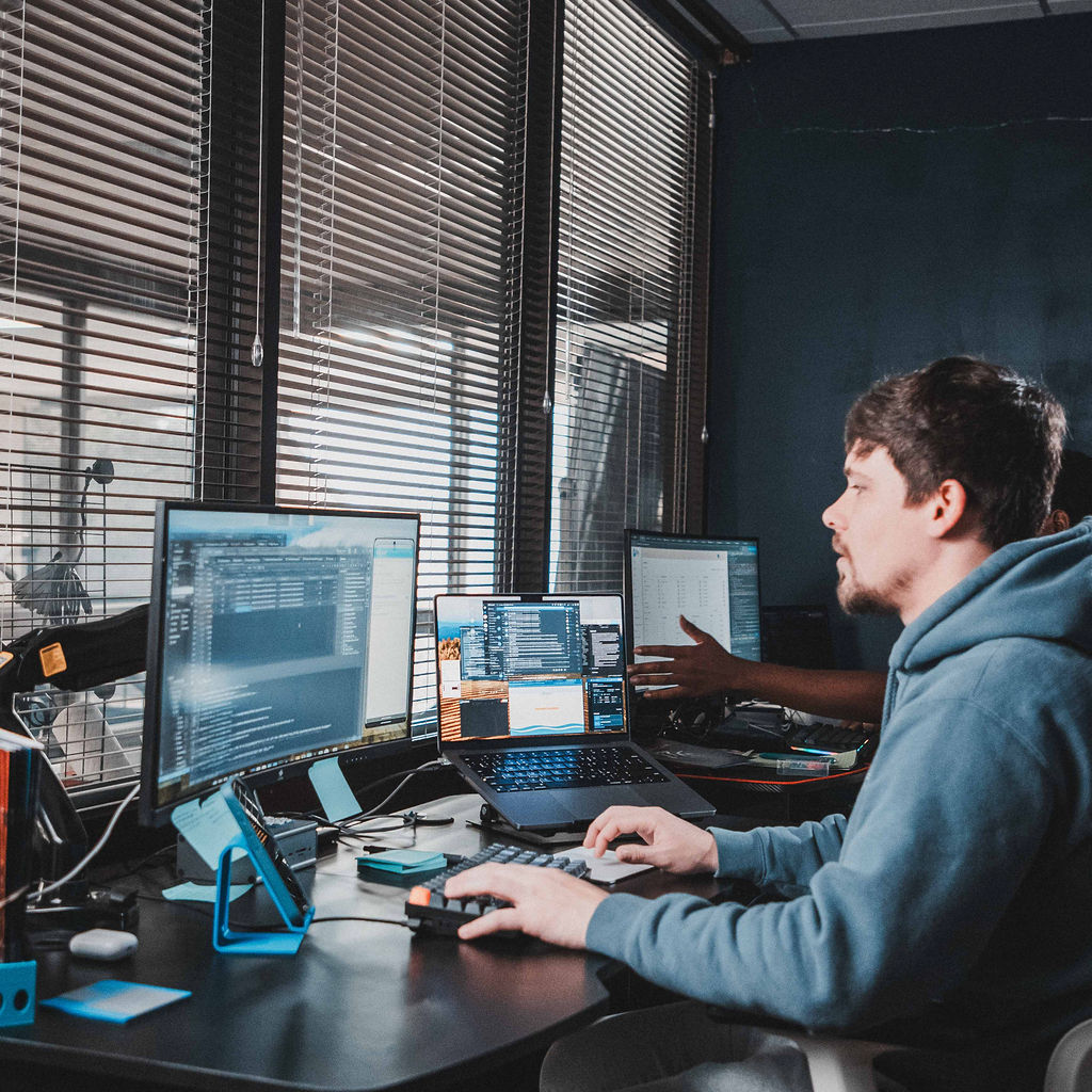 A Zelifcam developer working at a multi-monitor workstation